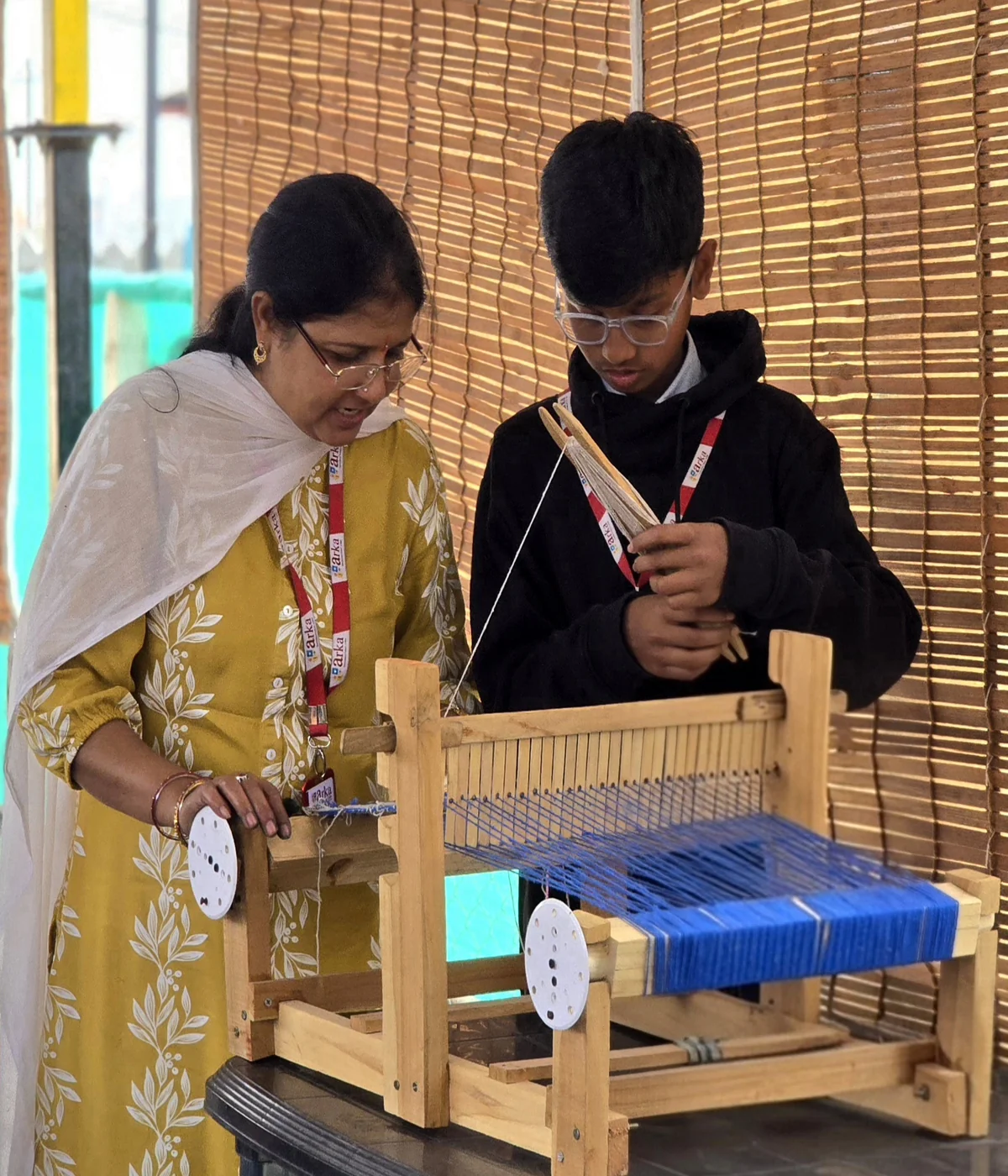 Student weaving on table top loom